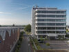 Titelbild der Kundenreferenz "Re-Organisation der IT " beim ORBIT-Kunden Reifenhäuser. Hochhaus, die Firmenzentrale, mit Straße vor blauem Himmel.