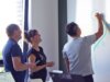 Menschen, die an einem Whiteboard stehen und planen. IT-Security Beratung und Umsetzung