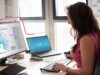 Frau sitzt am PC und schaut auf ein Bild eines IT-Security-Radars; IT-Security Beratung